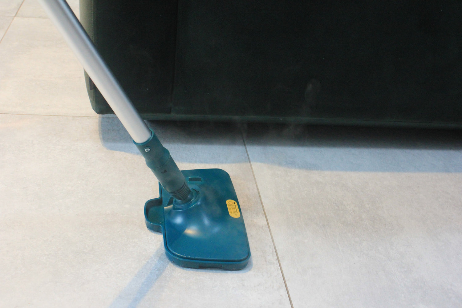 ScandiSteam dampmoppe rengør effektivt gulvet med damp på lyse fliser ved en sofa